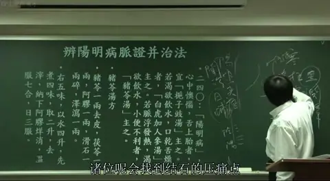  黑板板书，讲者手绘了一只脚的内侧解剖简图，明确标注了内踝、太溪穴及复溜穴的位置（太溪上两寸），用于讲解结石的针灸穴位。